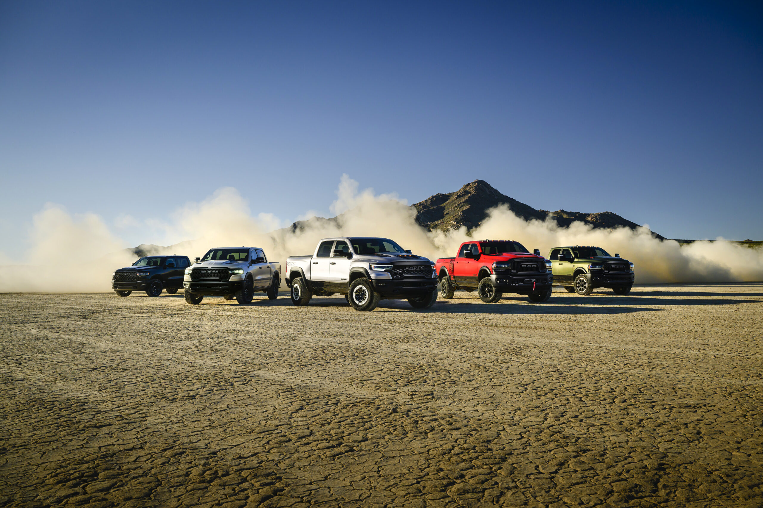 2025 RAM 1500 RHO vehicles line up in an arid desert-like field